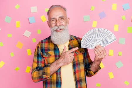 Photo of lucky cute mature man dressed checkered shirt finding great salary solution isolated pink...