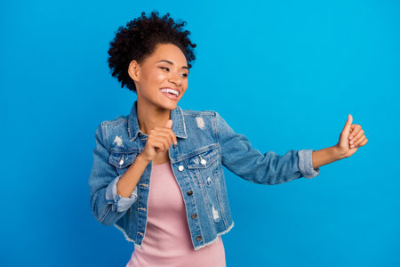 Photo of young cheerful happy woman dance look empty space smile isolated on blue color backgroundの写真素材