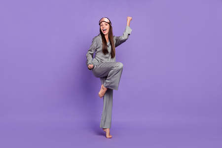 Full length body size view of attractive cheerful lucky woman rejoicing isolated over violet purple color backgroundの写真素材