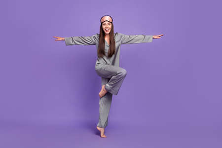 Full length body size view of attractive cheerful woman jumping like plane isolated over violet purple color backgroundの写真素材