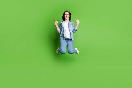 Full length body size view of attractive cheerful girl jumping having fun isolated over bright green...