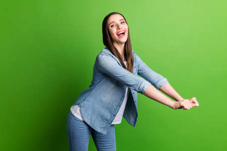 Portrait of attractive funky carefree cheerful girl having fun isolated over bright green color backgroundの写真素材