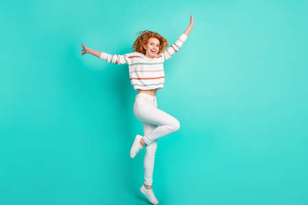 Full length body size view of lovely thin cheerful wavy-haired girl jumping having fun isolated over bright teal turquoise color backgroundの写真素材
