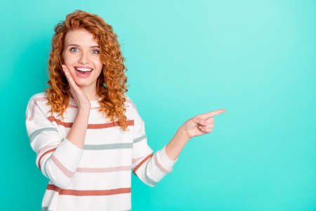 Portrait of attractive cheerful wavy-haired girl demonstrating copy space ad way isolated over...