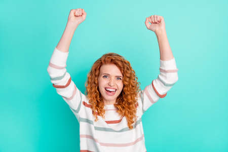 Photo of cheerful happy nice young woman raise fists winner celebrate isolated on teal color...