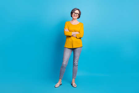 Full length body size view of attractive cheerful woman folded arms isolated over bright blue color backgroundの写真素材