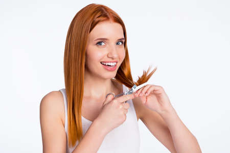 Photo of young attractive girl happy positive smile cut scissors red hair isolated over grey color backgroundの写真素材