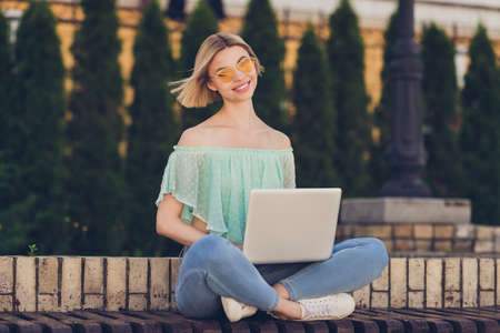 Full length photo of young girl happy positive smile sit bench use laptop browse internet online...