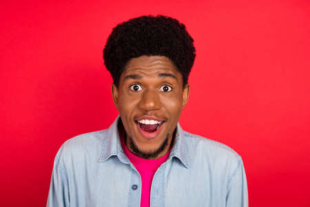 Portrait of attractive cheerful brunet guy good mood incredible sale isolated over bright red color backgroundの写真素材