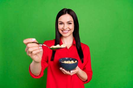 Photo of young woman happy positive smile hold plate spoon eat cereal cornflakes morning tasty...