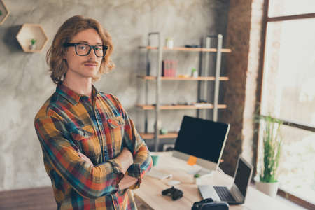 Photo portrait man in glasses checkered shirt crossed hands professional developer at officeの写真素材
