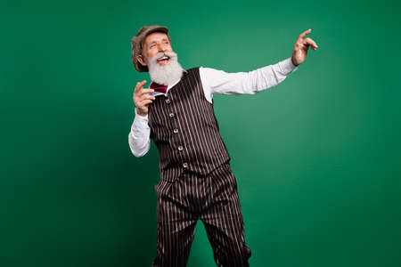 Photo of nice dreamy grandpa dance look empty space enjoy holiday wear hat striped suit scarf on...