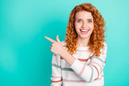 Photo portrait curly woman smiling pointing finger blank space cheerful isolated bright turquoise...