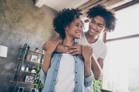 Photo of dark skin casual charming wife husband hug smile good mood embrace inside house home apartmentの写真素材