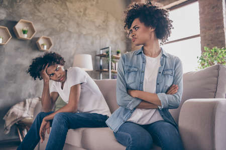 Photo of afro american angry couple young bad mood conflict sit sofa negative inside house home apartment flatの写真素材