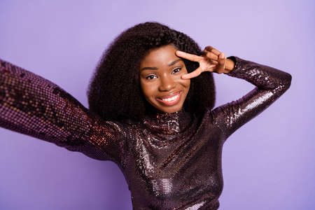 Photo of young pretty charming happy smiling african girl take selfie showing v-sign isolated on...