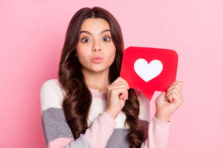 Photo of charming cheerful young girl hold like icon send air kiss isolated on pastel pink color...