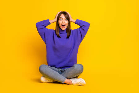 Portrait of attractive cheerful amazed girl sitting in lotus pose great news reaction isolated on bright yellow color backgroundの写真素材