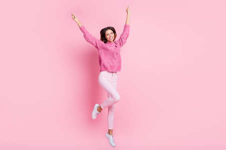 Full size photo of hooray cool brunette lady jump wear pink sweater trousers sneakers isolated on pink backgroundの写真素材
