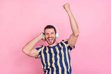 Portrait of attractive cheerful lucky guy listening hit dancing having fun isolated over pink pastel color backgroundの写真素材
