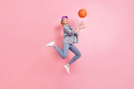 Full length profile photo of cool sporty lady catch ball jump wear jeans shirt cap isolated on pink...