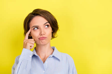 Photo of young attractive woman finger touch head think memory idea look empty space isolated over...
