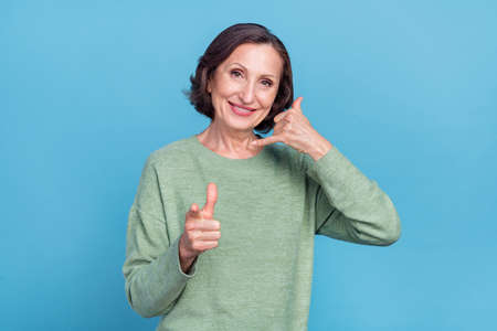 Photo of old grey hair woman ask to call wear green pullover isolated on blue color background
