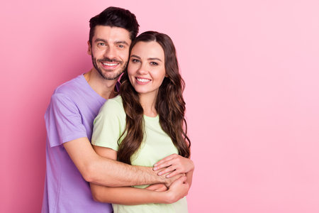 Portrait of attractive sweet tender cheerful couple embracing sweetheart isolated over pink pastel...