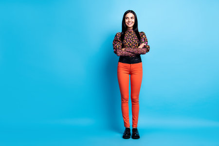 Photo of confident lady look empty space wear flower print shirt trousers shoes isolated blue color backgroundの写真素材