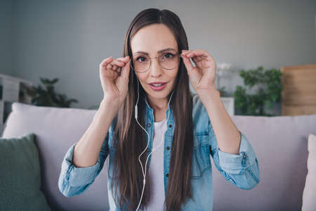 Portrait of attractive trendy cheerful woman sitting on divan using laptop calling web touching...