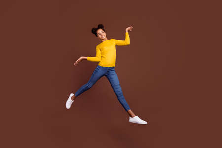 Full size photo of active preteen girl jump wear shirt jeans shoes isolated on brown color...