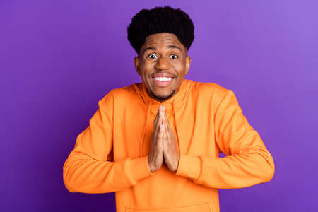 Photo of young afro guy happy positive smile excited hands together wait expect gift isolated over...