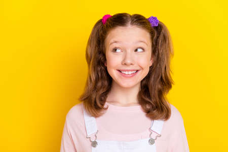 Photo portrait schoolgirl curious dreamy in casual clothes looking copyspace isolated bright yellow color backgroundの写真素材