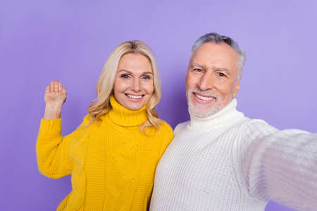 Photo of cute charming senior husband wife dressed knitwear sweaters hugging tacking selfie inviting...