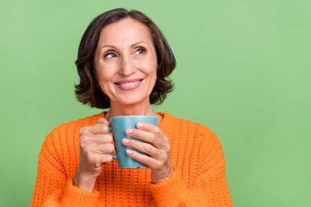 Photo of lovely retired woman interested curious look empty space drink latte espresso isolated over...
