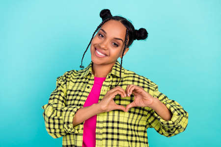 Photo of flirty millennial cool lady show heart wear yellow shirt isolated on teal color backgroundの写真素材