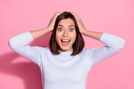 Photo of funny impressed young lady dressed white jumper shouting arms head knowing great news isolated pink color backgroundの写真素材