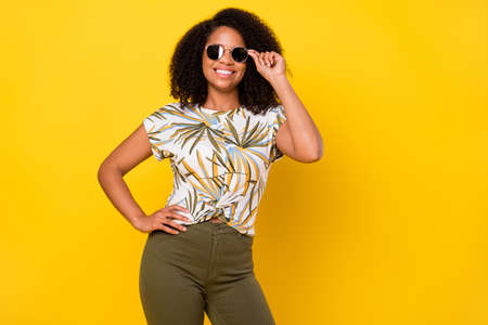 Photo of young attractive african woman good mood eyewear summer isolated over yellow color backgroundの写真素材