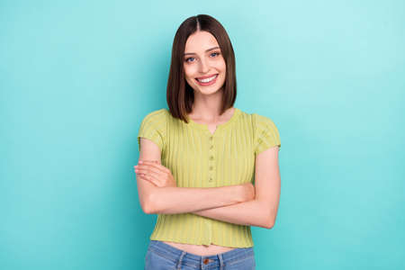Photo of self-assured cheerful lady crossed hands shiny smile wear green blouse isolated teal color...