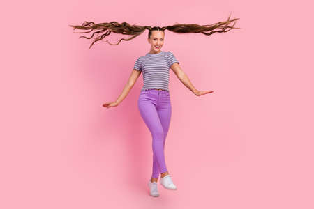 Photo of pretty charming young lady wear striped t-shirt smiling walking isolated pink color...