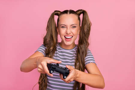 Photo of pretty funny young woman dressed striped t-shirt playing playstation smiling isolated pink color backgroundの写真素材