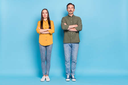 Full size photo of confident pretty lady successful handsome man folded hands isolated on blue color...