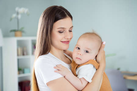 Photo of happy joyful dream family mom cuddle little small infant kid look camera wear white t-shirt...