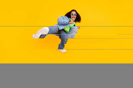 Photo of sweet pretty afro woman wear denim jacket arm dark glasses smiling beating leg isolated...