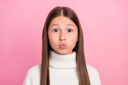 Portrait of attractive amourous flirty brown-haired girl sending air kiss isolated over pink pastel color backgroundの写真素材