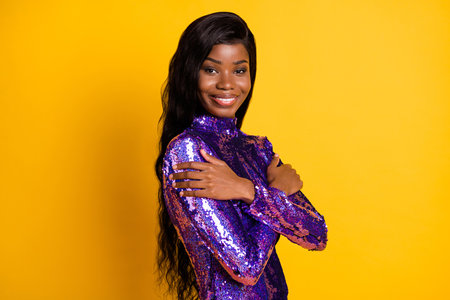 Profile side view portrait of attractive chic cheerful girl hugging herself isolated over bright yellow color backgroundの写真素材