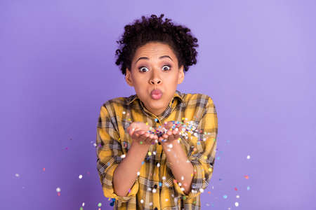 Photo of young african girl blow confetti party air fly holiday isolated over purple color...