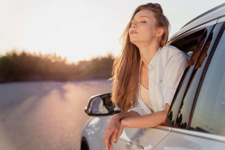 Photo portrait smiling woman riding in car on summer evening casual clothes spending free time alone