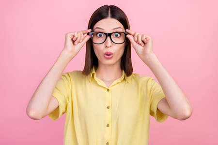 Photo of young attractive girl amazed shocked wear glasses vison ophthalmology isolated over pink...