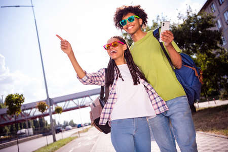 Photo of young african couple happy positive smile point finger excursion vacation trip town summer...